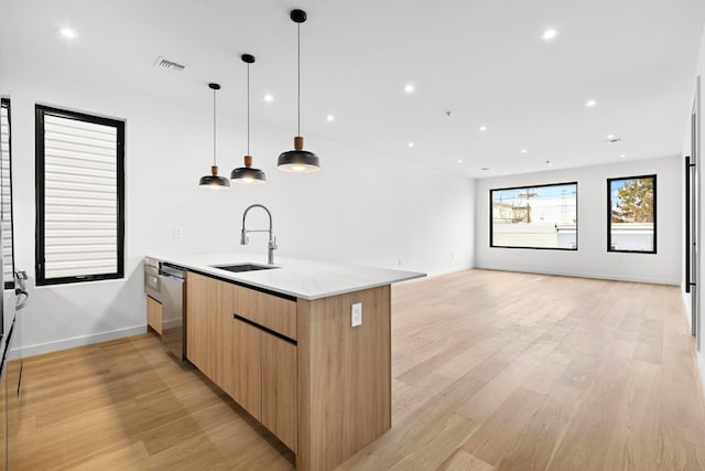 kitchen with a sink, open floor plan, dishwasher, modern cabinets, and pendant lighting