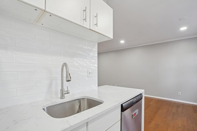 kitchen with sink, dishwasher, white cabinets, light stone countertops, and backsplash