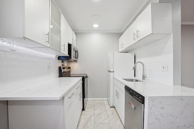 kitchen featuring sink, white cabinetry, backsplash, stainless steel appliances, and light stone counters