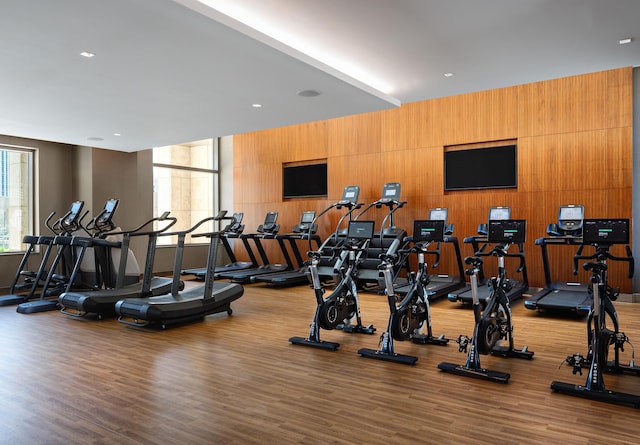 gym featuring hardwood / wood-style floors and wooden walls