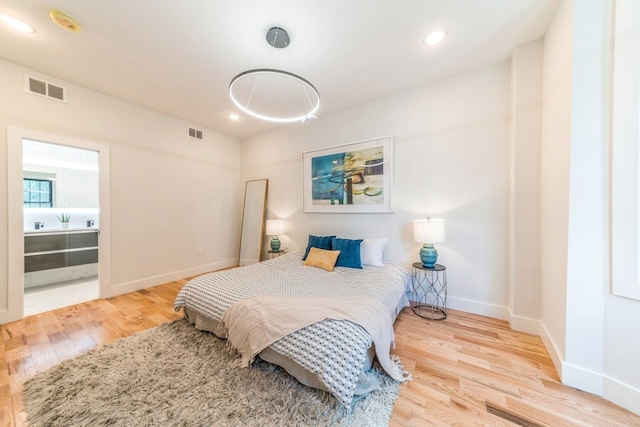 bedroom with hardwood / wood-style flooring and ensuite bathroom