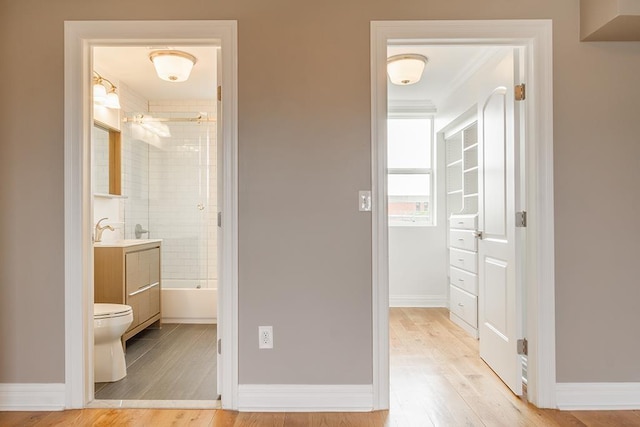 interior space with shower / bath combination, baseboards, and wood finished floors