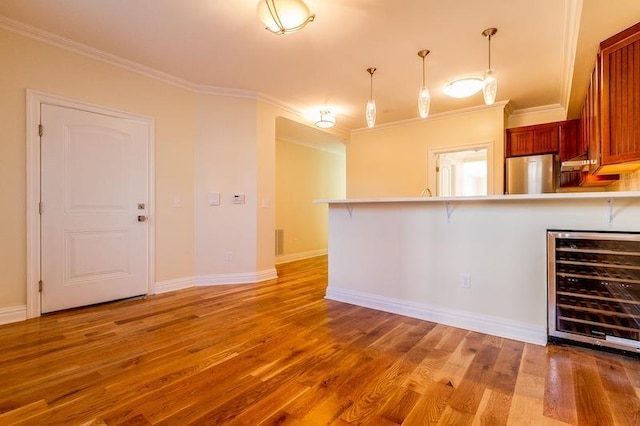 kitchen featuring freestanding refrigerator, beverage cooler, a peninsula, and light wood finished floors