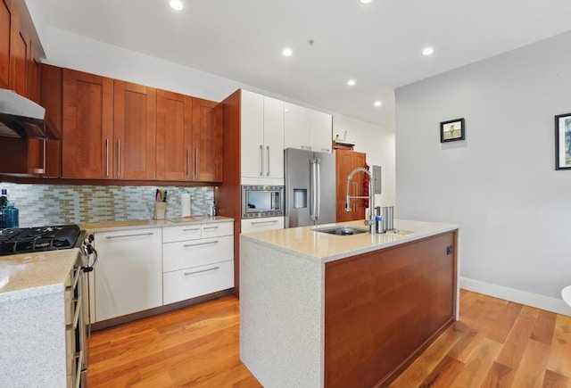 390 1st St Unit 2, Jersey City, NJ 07302 - kitchen featuring stainless steel appliances, under cabinet range hood, light wood-style floors, a sink, and tasteful backsplash
