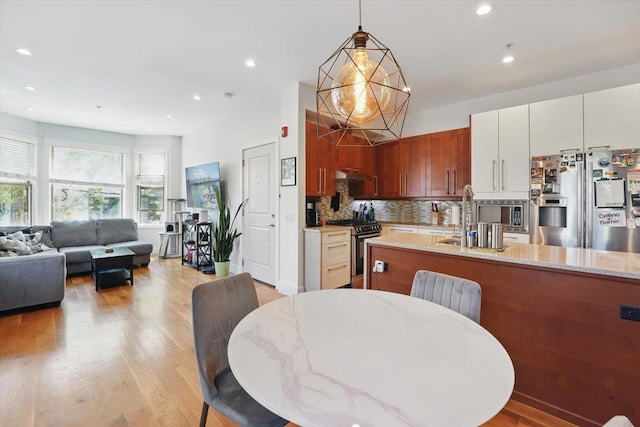 390 1st St Unit 2, Jersey City, NJ 07302 - kitchen with stainless steel appliances, backsplash, decorative light fixtures, light wood-style floors, and open floor plan