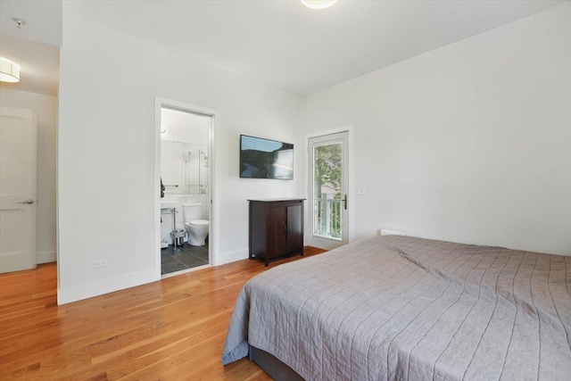 390 1st St Unit 2, Jersey City, NJ 07302 - bedroom with wood finished floors, baseboards, connected bathroom, and access to exterior