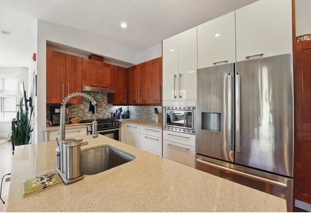 390 1st St Unit 2, Jersey City, NJ 07302 - kitchen with stainless steel appliances, light stone countertops, backsplash, a sink, and recessed lighting