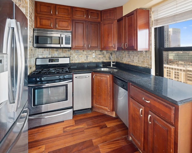 135 Montgomery St Unit A-19, Jersey City, NJ 07302 - kitchen with stainless steel appliances, dark wood-style flooring, backsplash, a peninsula, and dark stone countertops