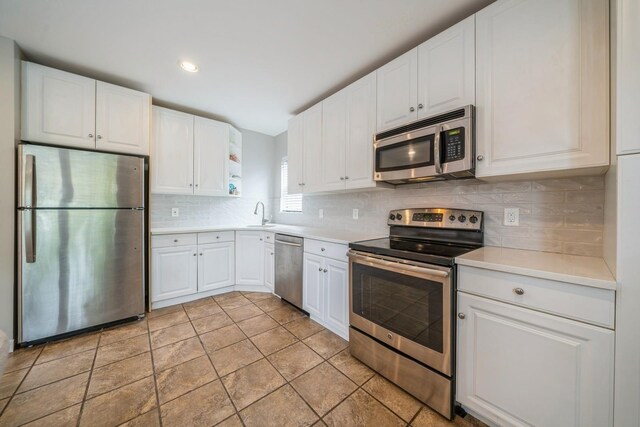 8915 Bergenwood Ave Unit 48, North Bergen, NJ 07047 - kitchen with appliances with stainless steel finishes, white cabinetry, light countertops, and decorative backsplash