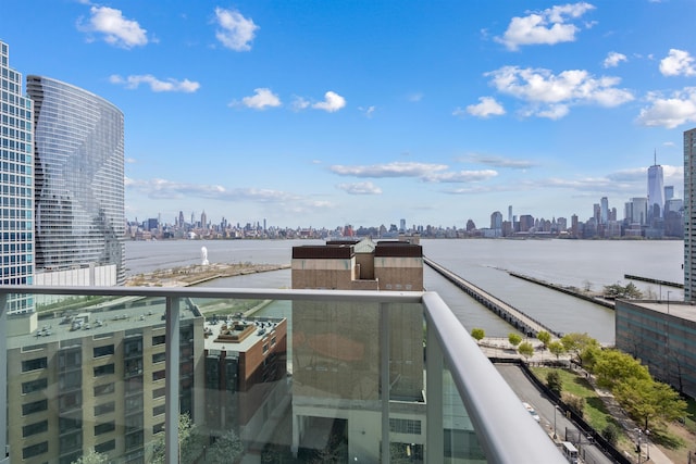 balcony with a water view and a view of city