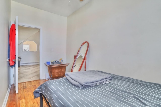 bedroom featuring light wood finished floors and baseboard heating