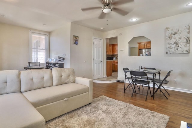 living area with ceiling fan, arched walkways, recessed lighting, dark wood-style flooring, and baseboards