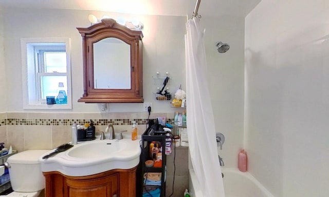 bathroom with toilet, vanity, and shower / tub combo with curtain