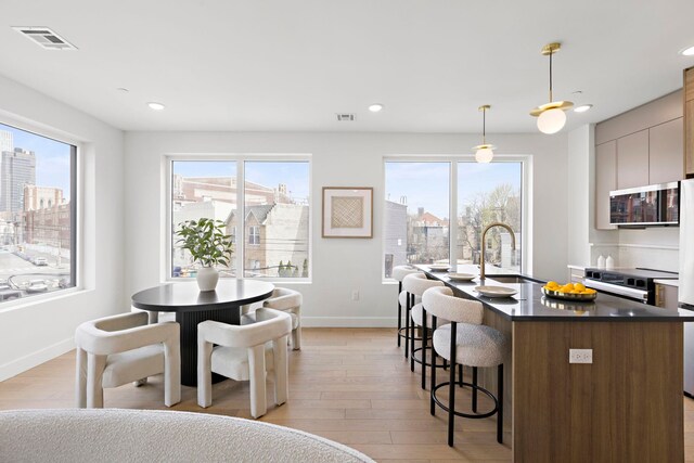35 Orchard St Unit 301, Jersey City, NJ 07306 - kitchen featuring a kitchen breakfast bar, visible vents, a sink, baseboards, and stainless steel microwave