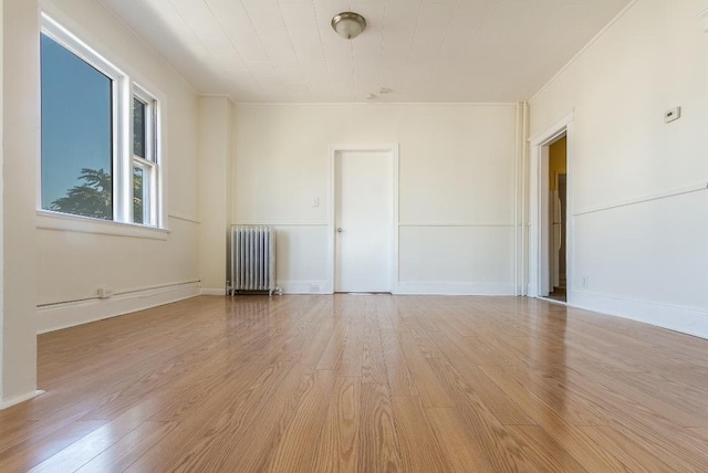 12 W 31st St, Bayonne, NJ 07002 - empty room with radiator heating unit, light wood-style flooring, and crown molding