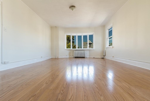 12 W 31st St, Bayonne, NJ 07002 - empty room featuring radiator, wood finished floors, and baseboards