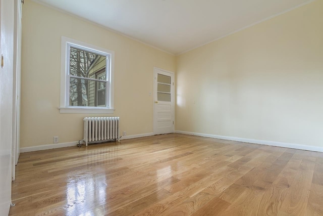 12 W 31st St, Bayonne, NJ 07002 - empty room featuring radiator, crown molding, wood finished floors, and baseboards