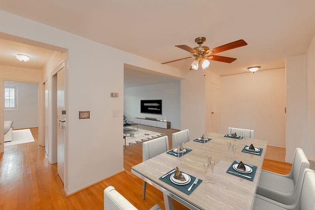 dining area with light hardwood / wood-style floors and ceiling fan