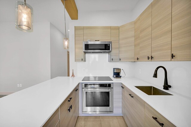 2505 Palisade Ave, Union City, NJ 07087 - kitchen featuring stainless steel appliances, a sink, light countertops, modern cabinets, and decorative light fixtures