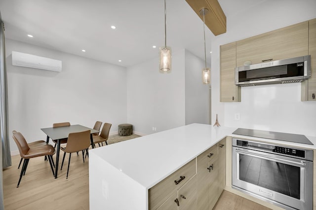 2505 Palisade Ave, Union City, NJ 07087 - kitchen featuring stainless steel appliances, a wall unit AC, a peninsula, light countertops, and light wood finished floors