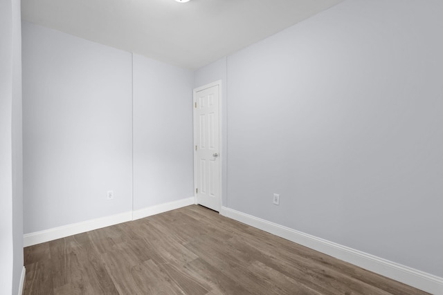 unfurnished room featuring baseboards and wood finished floors