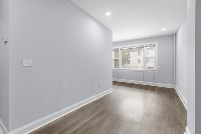 spare room with recessed lighting, baseboards, and wood finished floors