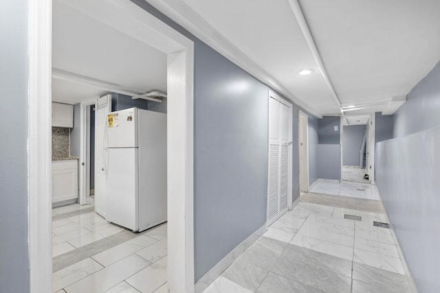 corridor with marble finish floor and baseboards