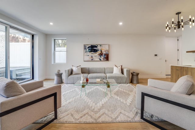 living area featuring baseboards, a chandelier, wood finished floors, and recessed lighting