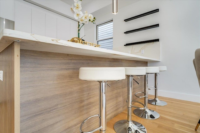 bar featuring wood finished floors and baseboards