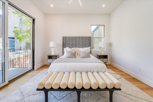 bedroom featuring access to outside, light wood-style flooring, baseboards, and recessed lighting