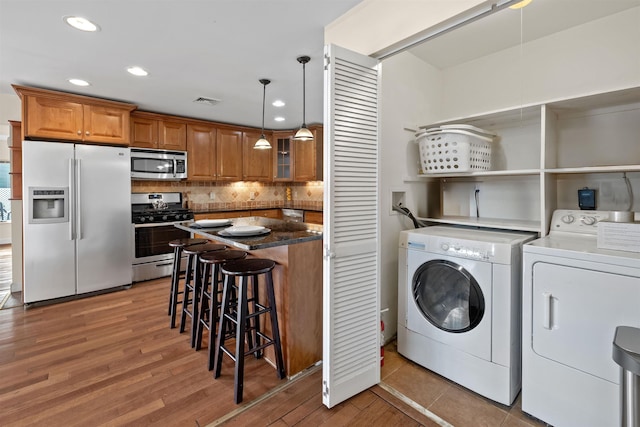 laundry room featuring separate washer and dryer and hardwood / wood-style flooring