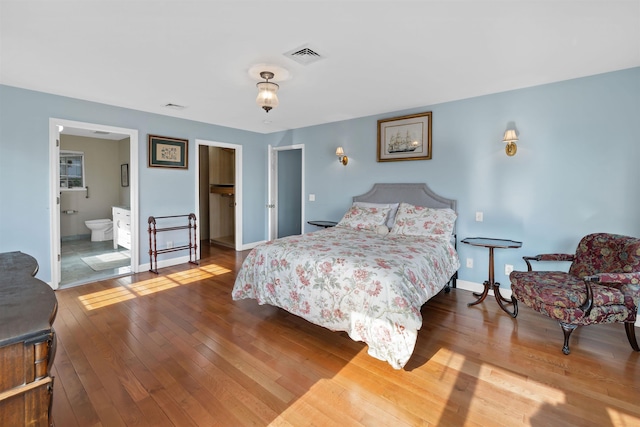 bedroom featuring connected bathroom and wood-type flooring