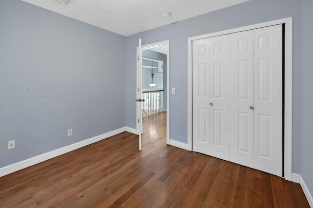 unfurnished bedroom featuring dark hardwood / wood-style flooring and a closet