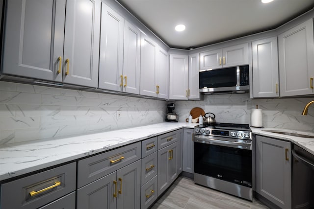 327 71st St Unit 1E, Guttenberg, NJ 07093 - kitchen with stainless steel appliances, gray cabinetry, a sink, decorative backsplash, and recessed lighting
