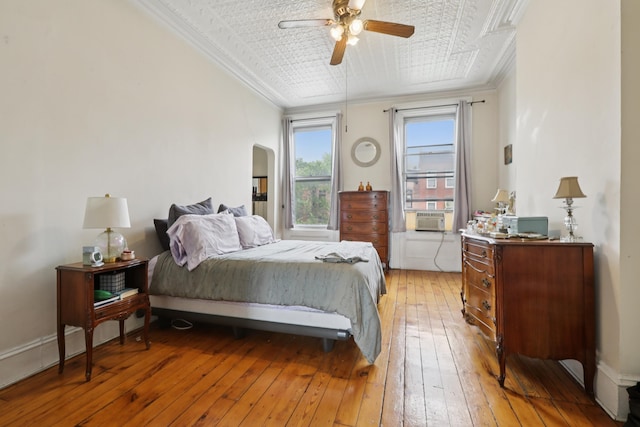 914 Washington St, Hoboken, NJ 07030 - bedroom featuring light wood-style flooring, crown molding, arched walkways, cooling unit, and ceiling fan
