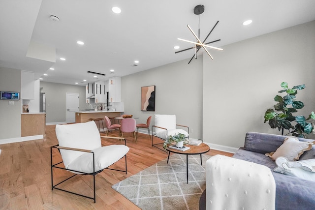 living area featuring baseboards, light wood finished floors, and recessed lighting