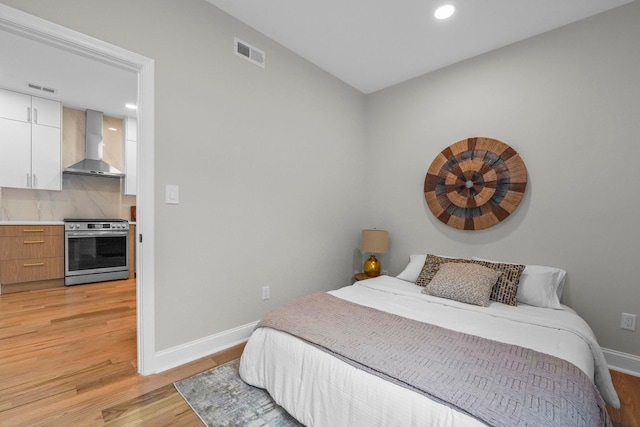 bedroom with light wood-type flooring, recessed lighting, baseboards, and visible vents