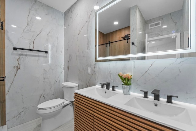 bathroom featuring visible vents, a sink, toilet, and double vanity