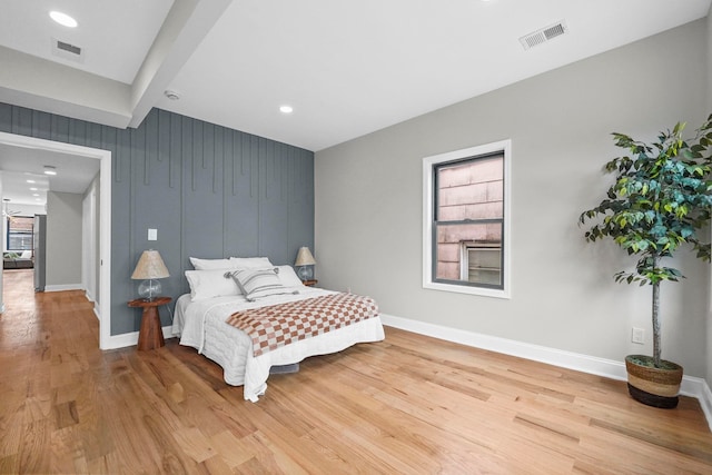 bedroom featuring baseboards, visible vents, and wood finished floors