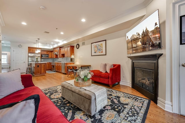 215 Monroe St Unit 3, Hoboken, NJ 07030 - living room with ornamental molding, a fireplace, light wood-style floors, and recessed lighting