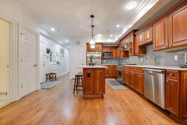 215 Monroe St Unit 3, Hoboken, NJ 07030 - kitchen with appliances with stainless steel finishes, brown cabinetry, light wood-type flooring, a breakfast bar area, and crown molding