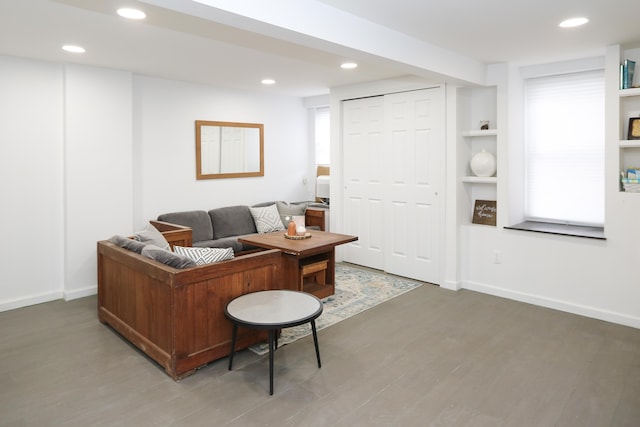 living area featuring built in features, recessed lighting, baseboards, and wood finished floors