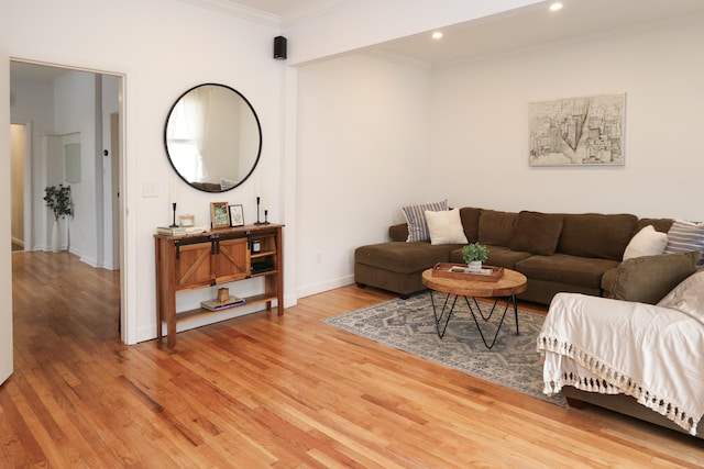 living room with light wood-type flooring, baseboards, ornamental molding, and recessed lighting