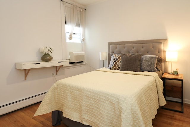 bedroom featuring a baseboard radiator and wood finished floors