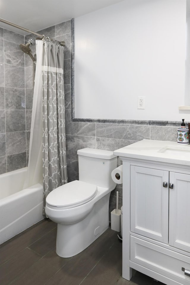 full bath featuring toilet, a wainscoted wall, wood finished floors, and tile walls