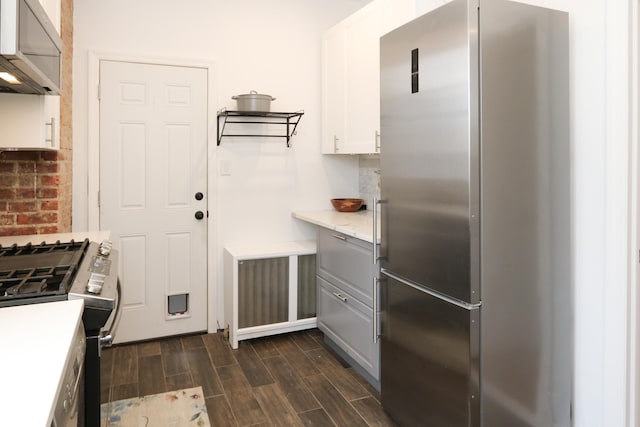 kitchen featuring white cabinets, light stone countertops, wood tiled floor, gray cabinets, and stainless steel appliances