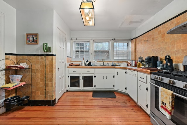 kitchen with white cabinets, light hardwood / wood-style floors, dishwasher, and stainless steel gas range oven