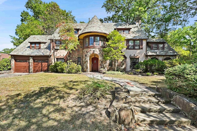 tudor house with a front yard and a garage