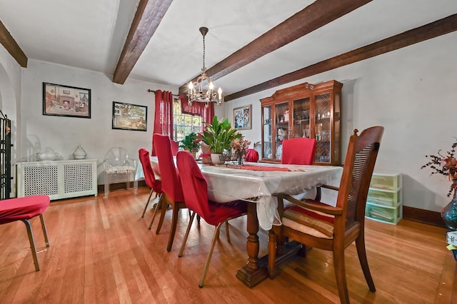 dining space featuring beamed ceiling, an inviting chandelier, and light hardwood / wood-style flooring