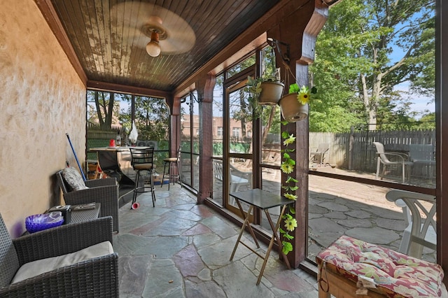 unfurnished sunroom with wooden ceiling and ceiling fan